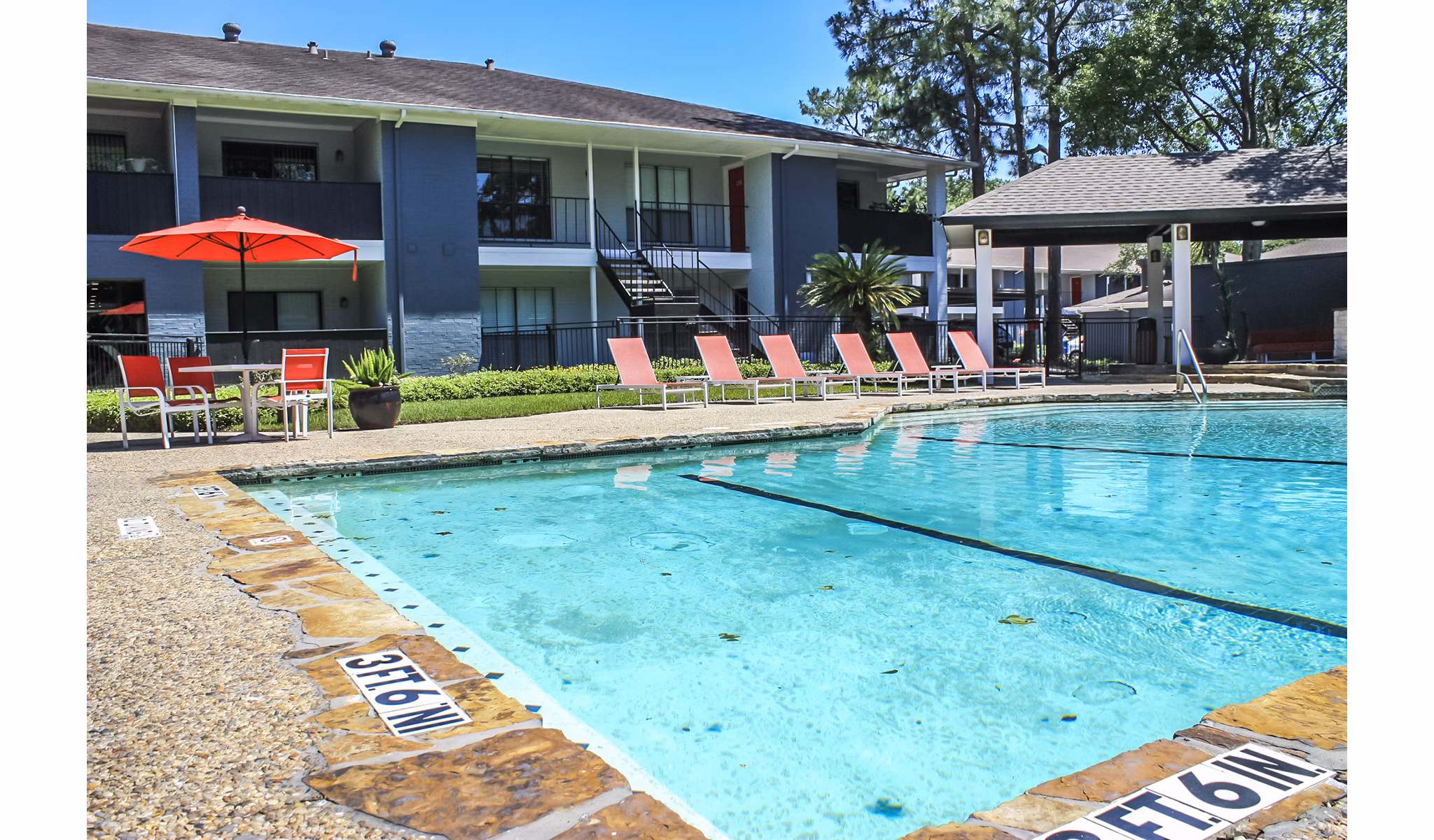 Sparkling outdoor pool at 3 Corners West Apartments, ideal for relaxation and sunbathing amidst luxury surroundings