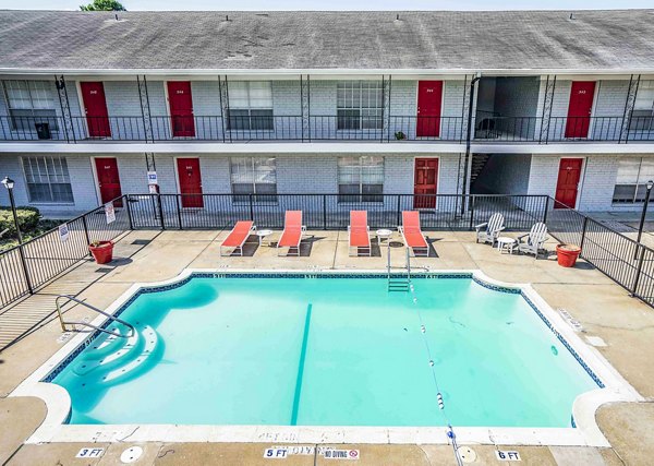 Scenic pool area at 3 Corners West Apartments, featuring surrounded loungers and lush greenery