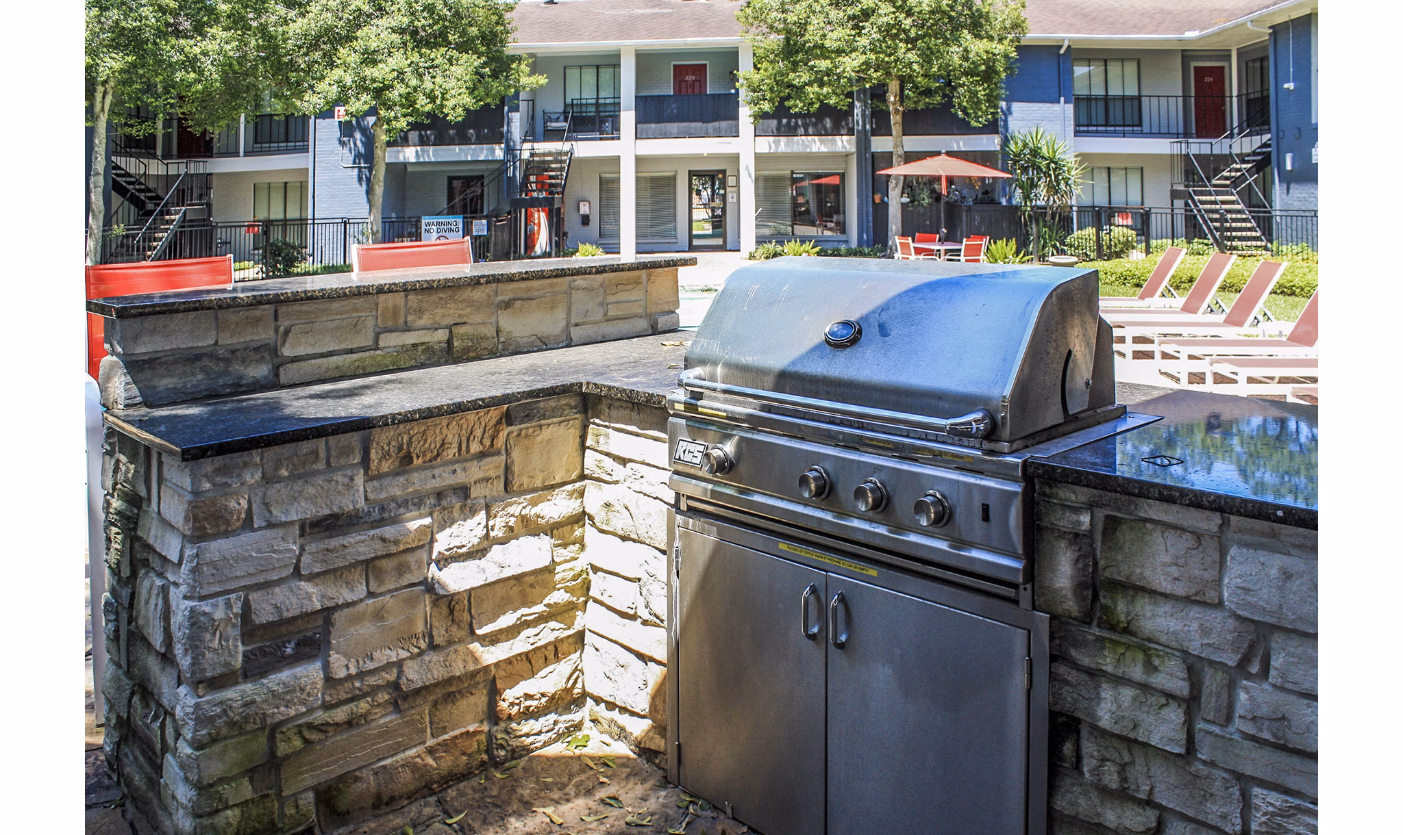Grill area at 3 Corners West Apartments: Outdoor cooking station with modern grills and seating for gatherings