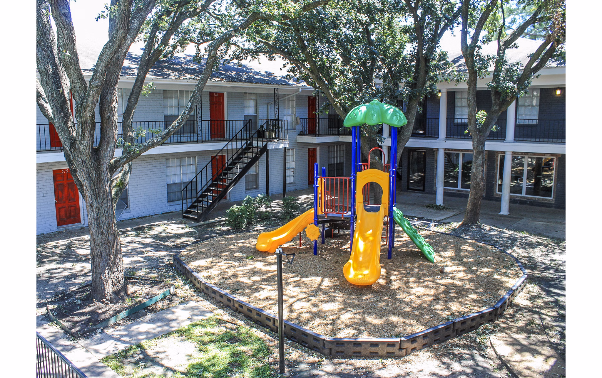 Modern playground at 3 Corners West Apartments with slides and climbing structures, ideal for families seeking active outdoor fun