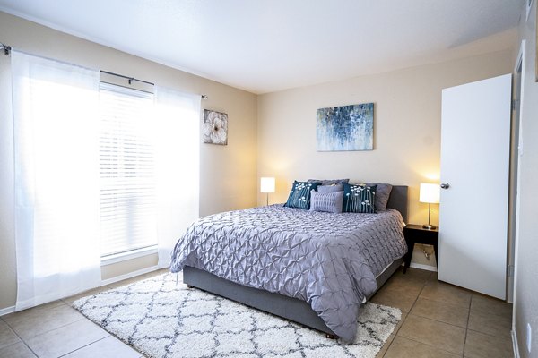 Cozy bedroom with modern decor and large windows at Hammerly Oaks Apartments