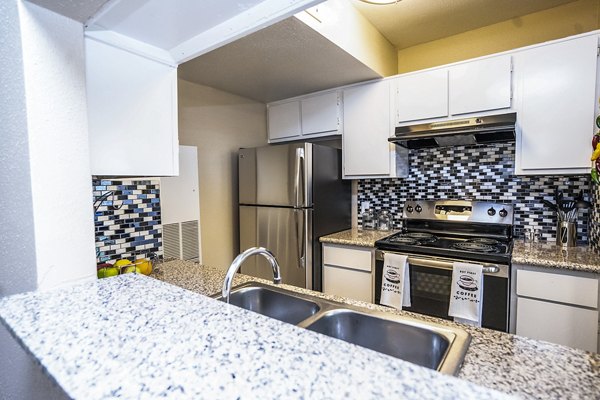 Modern kitchen with granite countertops and stainless steel appliances at Hammerly Oaks Apartments