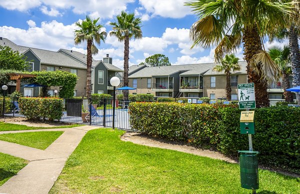 Dog-friendly park area at Hammerly Oaks Apartments offering green space and agility equipment for residents and their pets