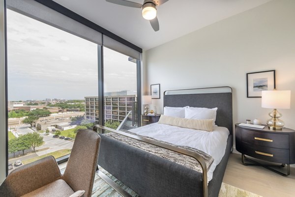 Modern bedroom with large windows and contemporary furnishings at Eastline Residences Apartments in Greystar luxury community