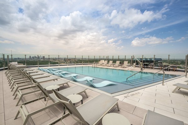 Sunlit pool with surrounding lounge chairs at Eastline Residences Apartments, a luxury community offering premium amenities in the heart of the city