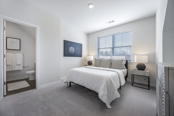 Bedroom featuring modern decor and ample natural light at Woodside Trumbull Apartments