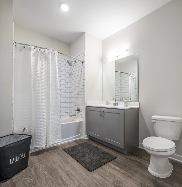 Bathroom featuring modern fixtures and marble countertop at Woodside Trumbull Apartments