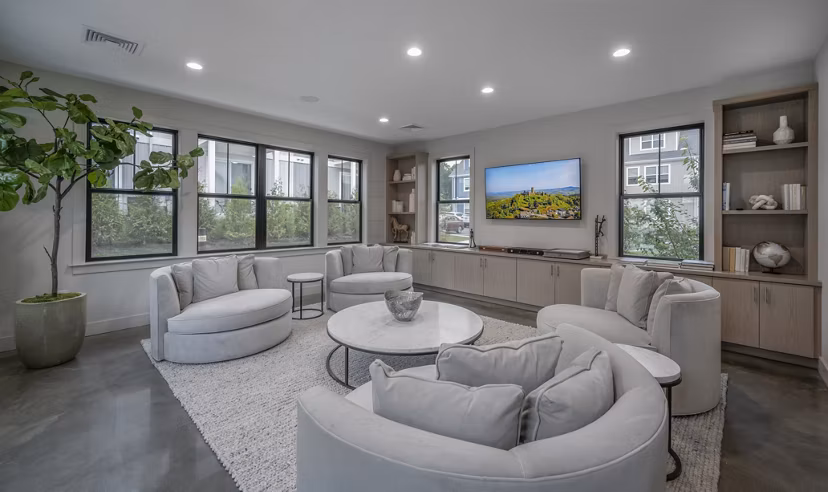Clubhouse featuring modern design and cozy seating at Woodside Trumbull Apartments