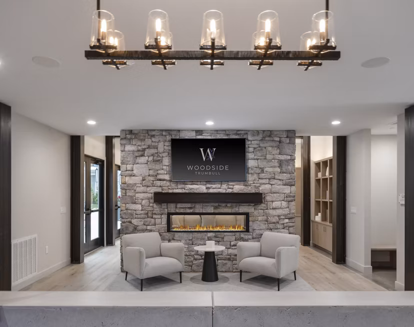 Clubhouse featuring modern furnishings and spacious seating at Woodside Trumbull Apartments, luxury living redefined