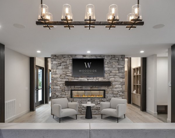 Clubhouse featuring modern furnishings and spacious seating at Woodside Trumbull Apartments, luxury living redefined