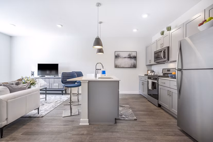 Modern kitchen with stainless steel appliances in Woodside Trumbull Apartments