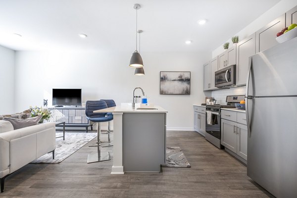 Modern kitchen with stainless steel appliances in Woodside Trumbull Apartments