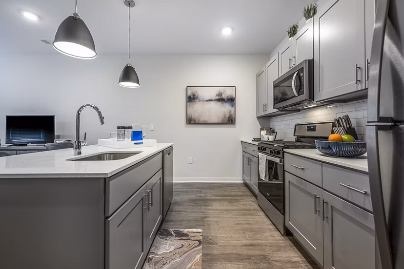 Modern kitchen with stainless steel appliances at Woodside Trumbull Apartments