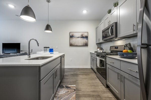 Modern kitchen with stainless steel appliances at Woodside Trumbull Apartments