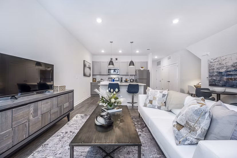 Cozy living room with modern furnishings and natural light at Woodside Trumbull Apartments
