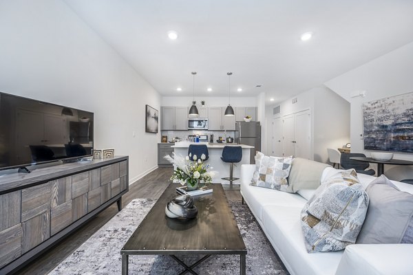 Cozy living room with modern furnishings and natural light at Woodside Trumbull Apartments