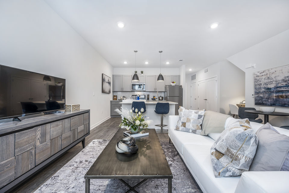 Cozy living room with modern furnishings and natural light at Woodside Trumbull Apartments