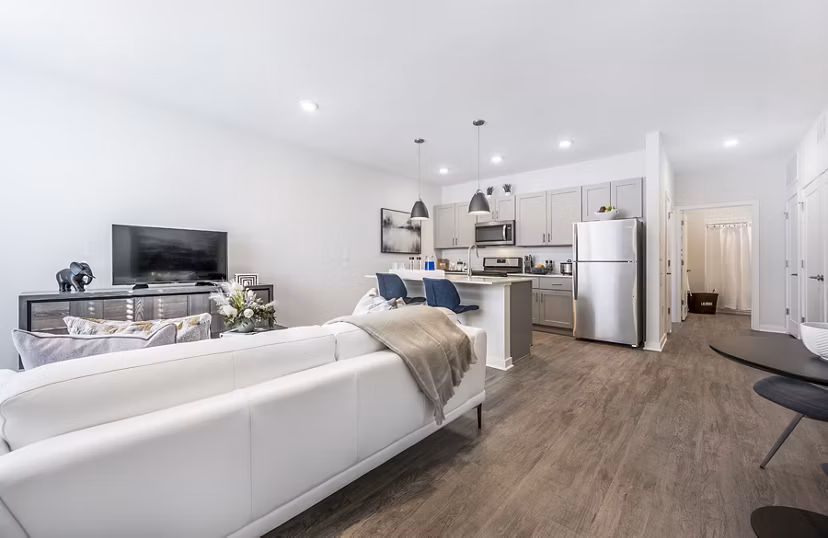 Modern living room with plush seating and large windows at Woodside Trumbull Apartments, offering comfort and style
