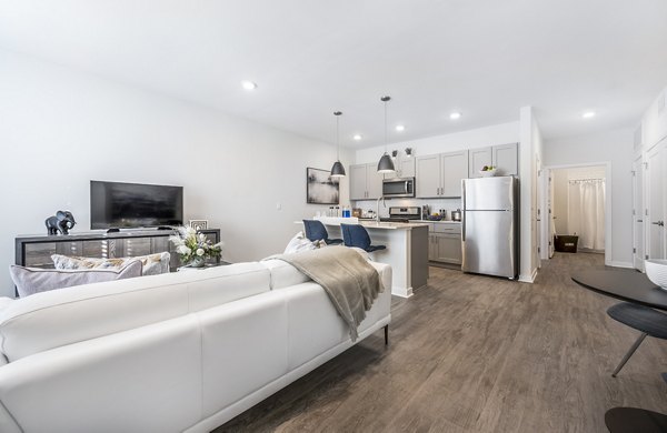 Modern living room with plush seating and large windows at Woodside Trumbull Apartments, offering comfort and style