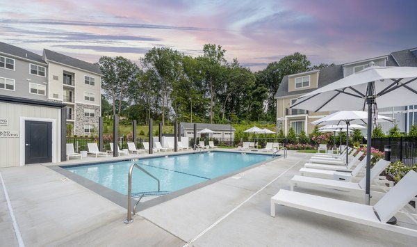 Resort-style pool surrounded by lush landscaping at Woodside Trumbull Apartments, ideal for relaxation and leisure activities