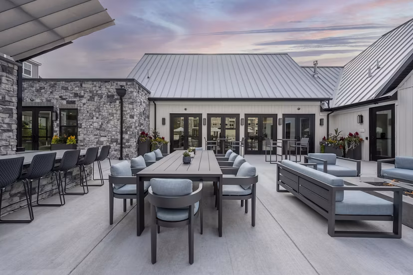 Charming landscaped courtyard at Woodside Trumbull Apartments, featuring outdoor seating and lush gardens