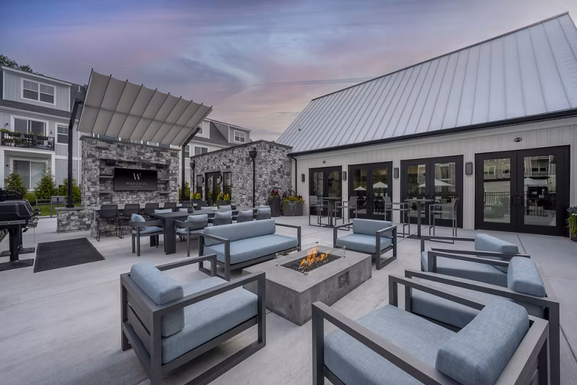 Fire pit surrounded by cozy seating area at Woodside Trumbull Apartments, offering a warm outdoor gathering space for residents
