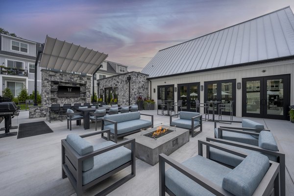 Fire pit surrounded by cozy seating area at Woodside Trumbull Apartments, offering a warm outdoor gathering space for residents