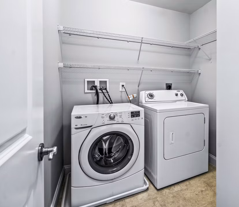 Laundry room with modern appliances at The Preserve at Cohasset Apartments