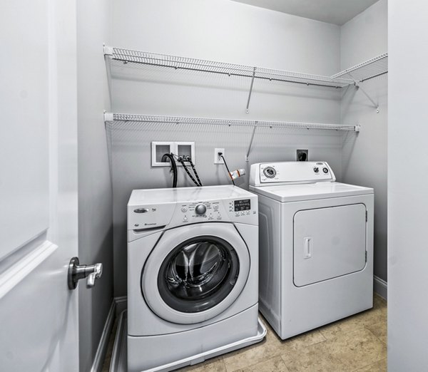 Laundry room with modern appliances at The Preserve at Cohasset Apartments