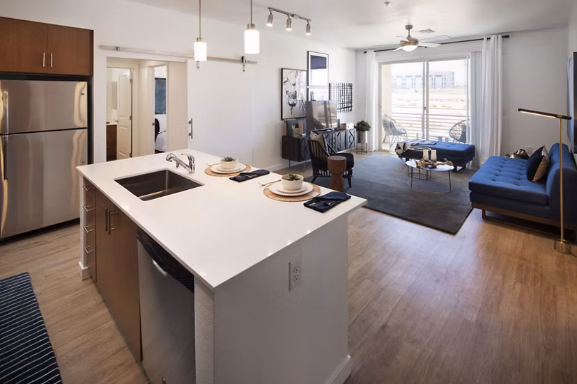 Kitchen with stainless steel appliances and quartz countertops at The Well Apartments
