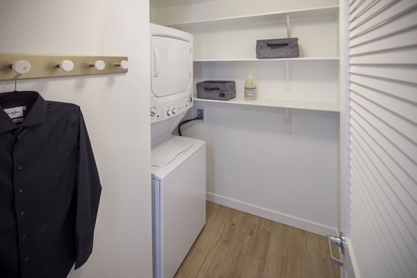Laundry room featuring state-of-the-art appliances at The Well Apartments, offering modern convenience and style for residents