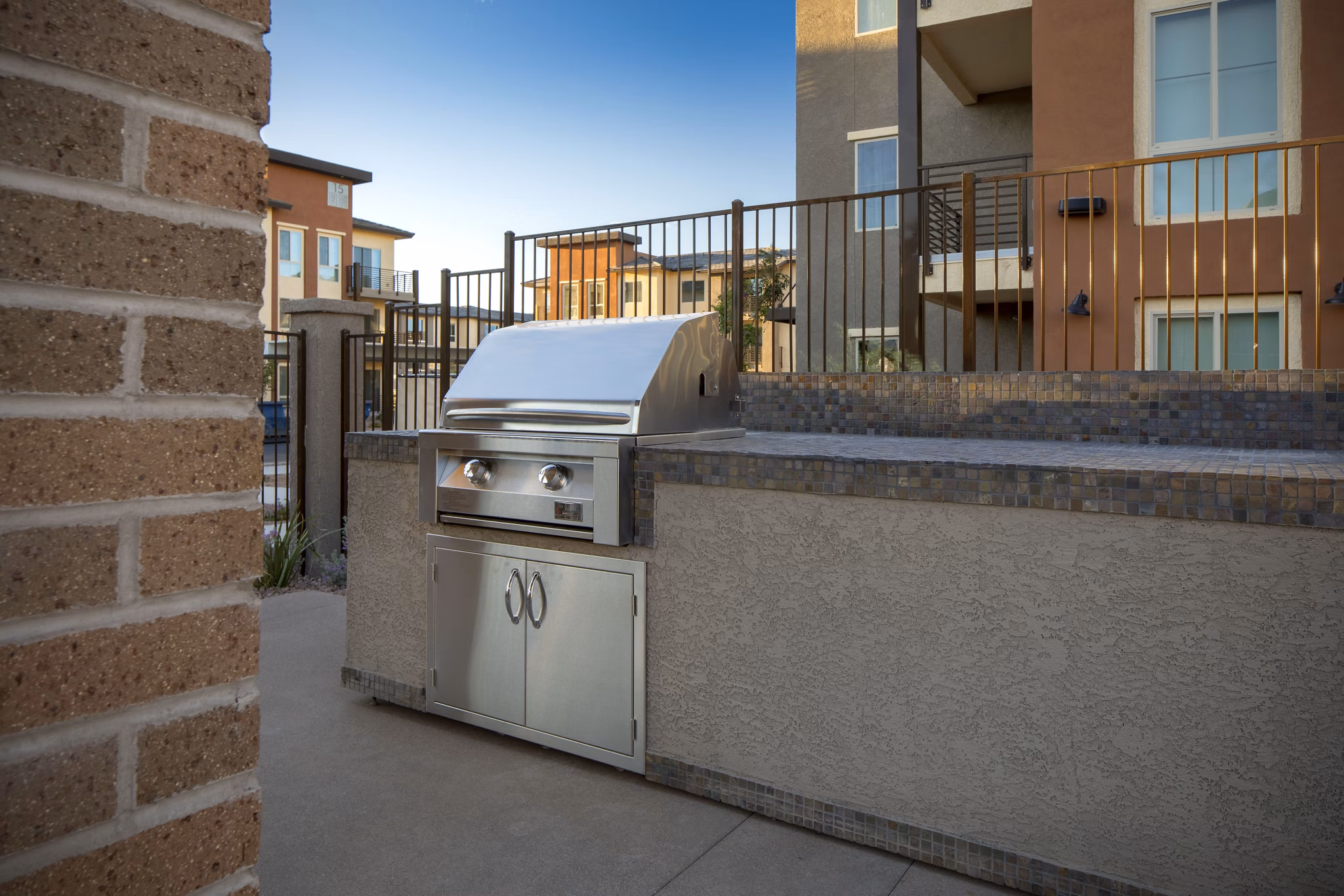 Modern outdoor grill area with seating at The Well Apartments