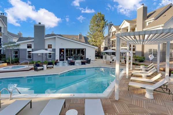 Infinity-edge pool surrounded by lush greenery at The Marks Apartments, offering luxury leisure in a serene setting