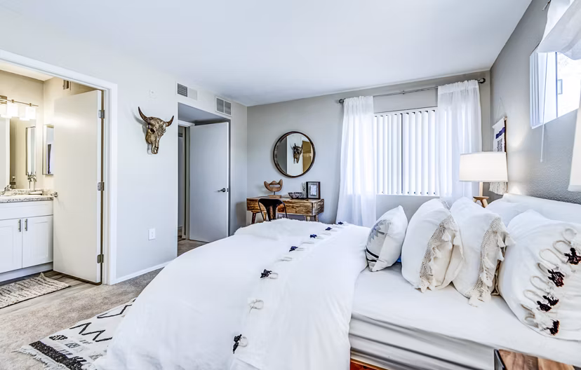 Sleek bedroom featuring modern decor and large windows at HUE97 Apartments