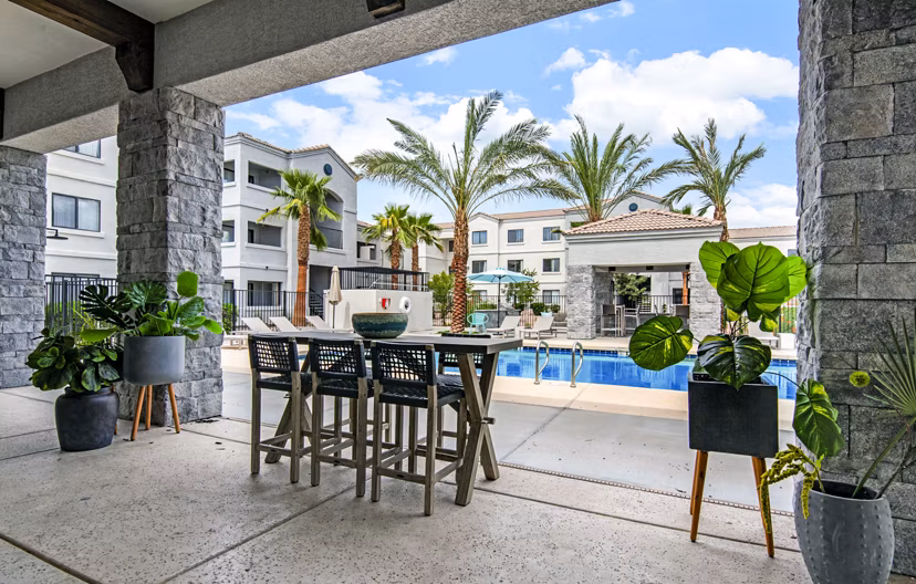 Pool patio with lounge chairs and city views at HUE97 Apartments
