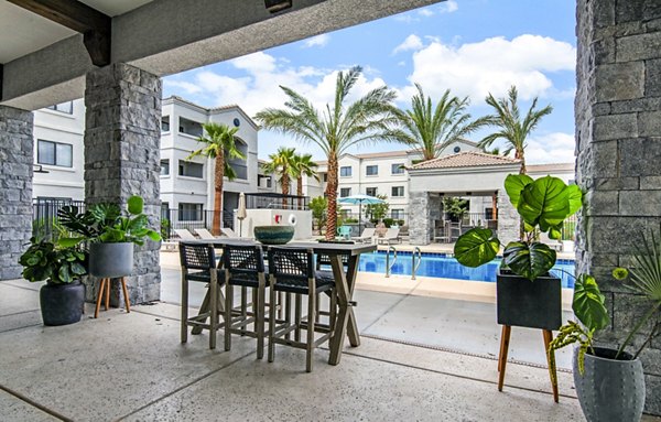 Pool patio with lounge chairs and city views at HUE97 Apartments