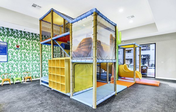 Indoor playground featuring vibrant play structures at HUE97 Apartments, a Greystar luxury offering