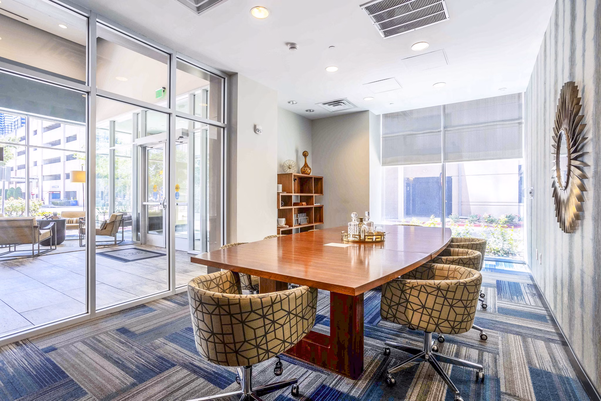 Spacious meeting room with modern seating and projection screen at SoDo on Main North Apartments clubhouse