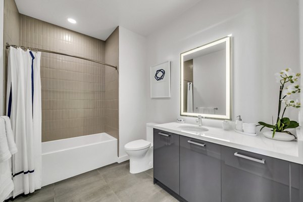 Bathroom with modern fixtures and marble countertops in Kurve Apartments, a luxury Greystar property