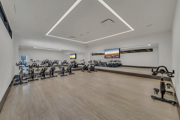 Yoga and spin studio with mirrored walls and modern equipment at Kurve Apartments, a premium living community promoting wellness