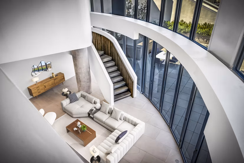 Modern living room with sleek furnishings and large windows at Kurve Apartments, a Greystar luxury residence
