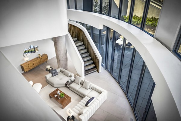 Modern living room with sleek furnishings and large windows at Kurve Apartments, a Greystar luxury residence