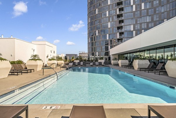 Resort-style pool with lounging area at Kurve Apartments