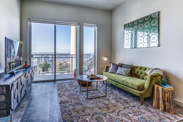 Spacious living room featuring modern decor and large windows in Batik Apartments