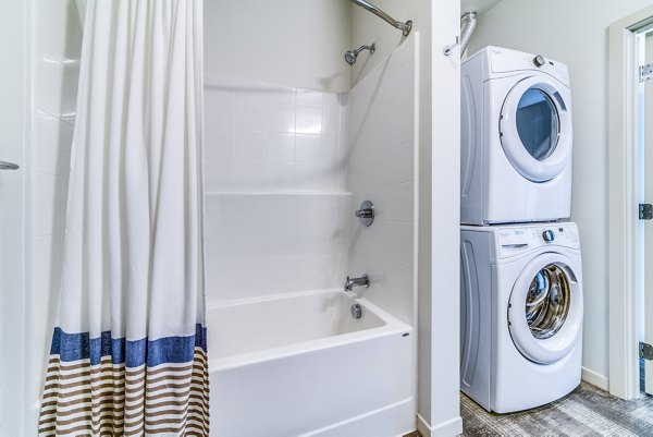 Boutique bath and laundry room with modern appliances in Batik Apartments