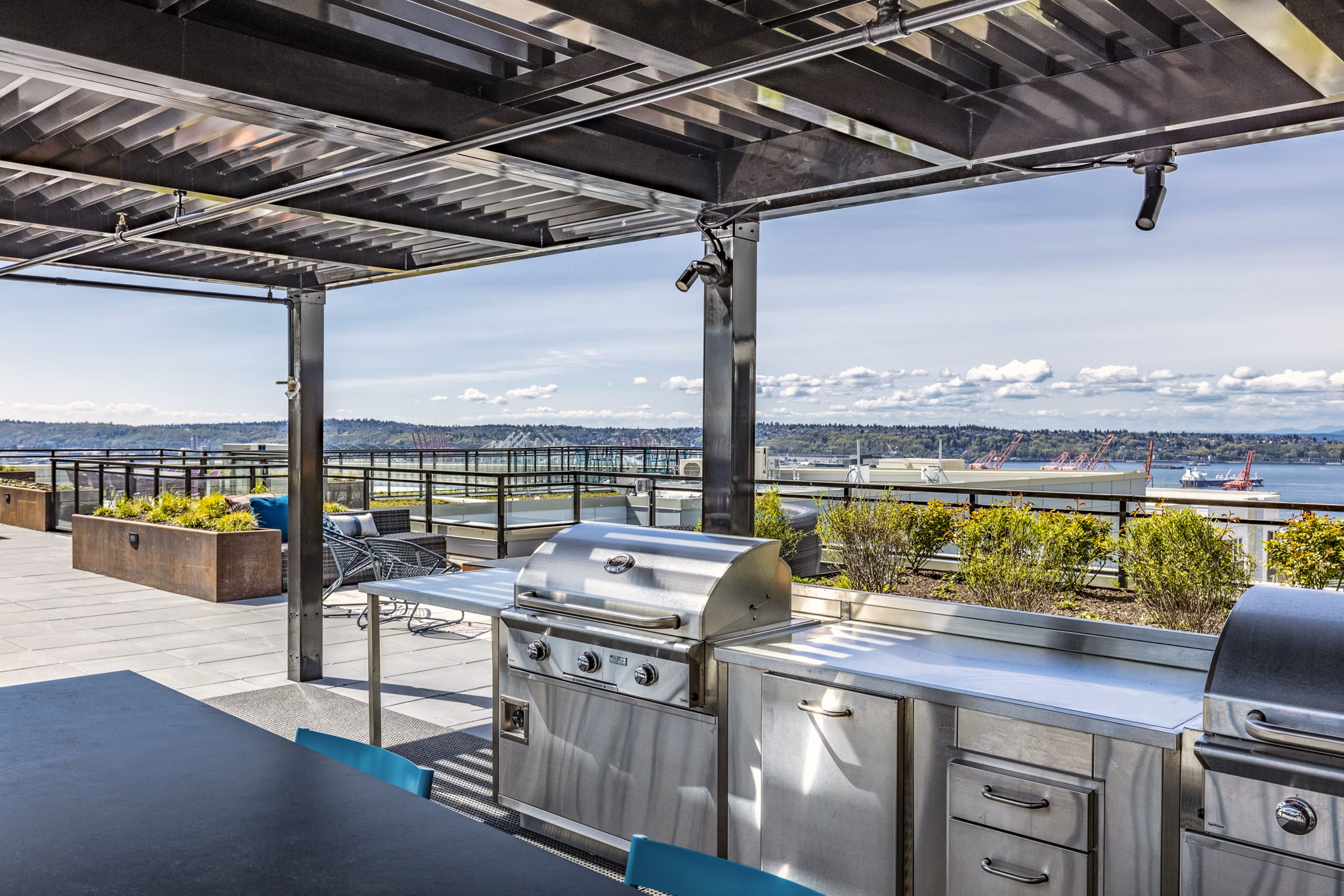 Grill area with modern seating and lighting on patio at Batik Apartments