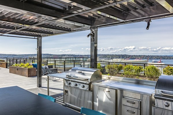 Grill area with modern seating and lighting on patio at Batik Apartments