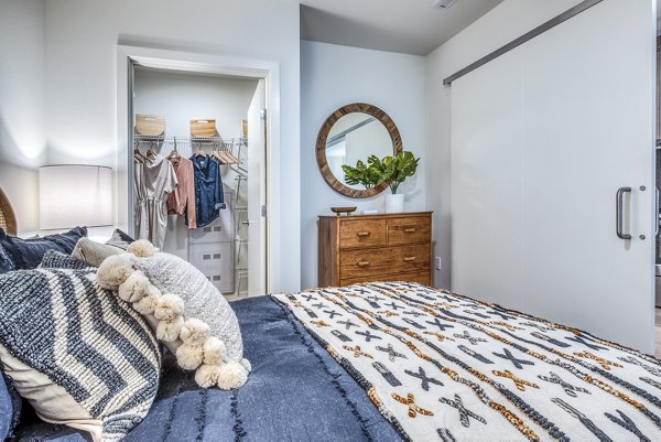 Bedroom with modern decor and large window in Cypress Apartments, a luxury property by Greystar