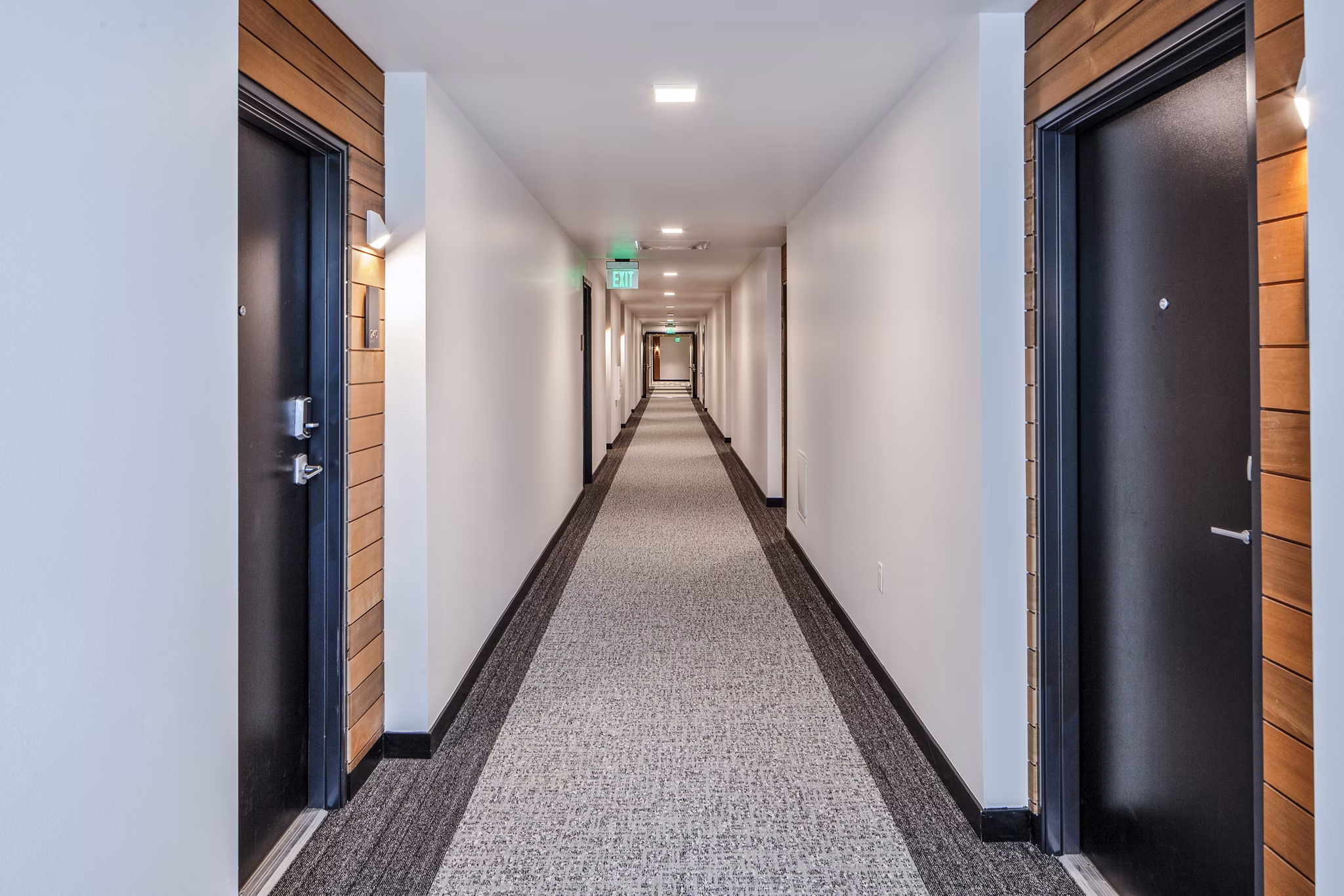 Wide hallway with modern lighting at Cypress Apartments, a Greystar luxury residence