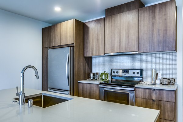 Modern kitchen with stainless steel appliances in Cypress Apartments